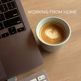 a cup of coffee on a table next to a laptop